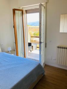 a bedroom with a bed and a door to a balcony at Guido's Apartment Villa Romana in Desenzano del Garda