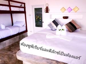 a bedroom with two bunk beds with white sheets at Sabai Sabai Beach Bungalows in Ko Phayam