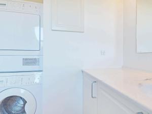 a white laundry room with a washing machine at 4 person holiday home in Blåvand in Blåvand