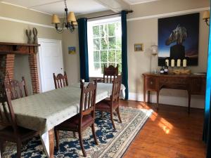 a dining room with a table and chairs and a window at Apuldram Manor farm in Chichester