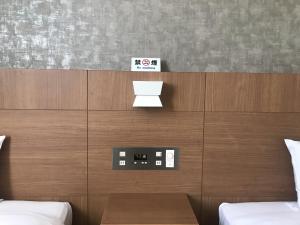 銚子市にあるホテルサンライズ銚子のベッド2台と壁掛け時計が備わる客室です。