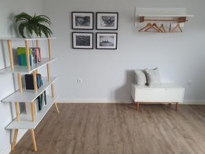 a living room with white shelves and a plant at Ferienwohnung Südwesthörn in Emmelsbüll-Horsbüll