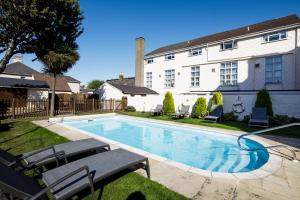 a swimming pool in front of a house at Ommaroo Hotel in Saint Helier Jersey