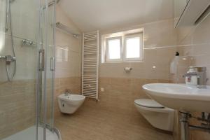 a bathroom with a sink and a toilet and a shower at Apartments Sucic Iva i Tea in Soline