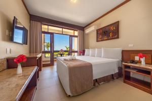 ein Schlafzimmer mit einem großen Bett und einem großen Fenster in der Unterkunft Quinta do Sol Praia Hotel in Porto Seguro