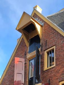 une maison avec une fenêtre ouverte sur son côté dans l'établissement B&B Pakhuis Emden, à Groningue