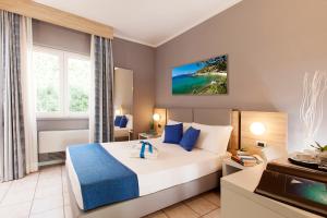 a hotel room with a large bed with blue accents at Bike&Boat Argentario Hotel in Porto Santo Stefano