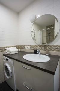 Baron Old Town Apartments في فيلنيوس: حمام مع حوض ومرآة