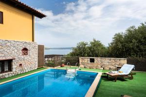 a pool with a view of the water and a house at Villa Georgia in Kalyves