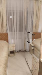 a bedroom with a bed and a window with curtains at Sladjawing1 in Jagodina
