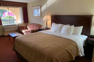 una habitación de hotel con una cama grande y una silla en Days Inn by Wyndham Blythe, en Blythe