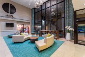 a lobby with couches and chairs on a blue rug at Wyndham Virginia Beach Oceanfront in Virginia Beach
