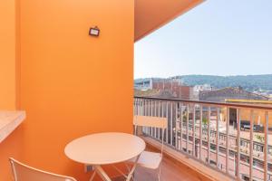 una mesa y sillas en un balcón con vistas en Hauzify I Apartament Big Family en Sant Feliu de Guixols