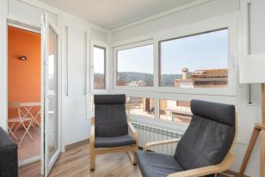 two chairs in a room with a window at Hauzify I Apartament Big Family in Sant Feliu de Guíxols