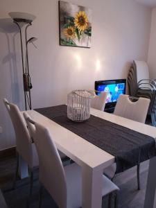 uma mesa de jantar com cadeiras brancas e um computador portátil em Apartment Mojca em Bovec