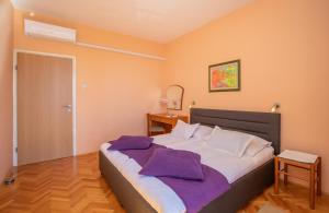 Un dormitorio con una cama grande con almohadas moradas. en Apartment Ploče Marina, en Dubrovnik