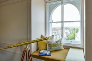 a telescope sitting on a bench next to a window at The Langham London in London