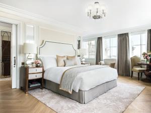 a bedroom with a large bed and a chandelier at The Langham London in London