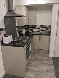a kitchen with a counter with wine glasses on it at Driftwood Apartment - Skegness in Skegness