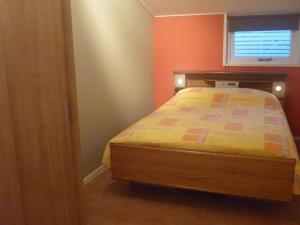 een slaapkamer met een bed in een kamer met een raam bij Child friendly apartment on a farm with garden in Fochteloo