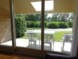 a glass door leading to a patio with a table and chairs at Child friendly apartment on a farm with garden in Fochteloo in Fochteloo