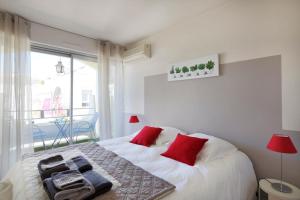 a bedroom with a bed with red pillows on it at Cosy and large flat in the hypercentre of Avignon Provence - Welkeys in Avignon