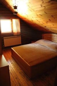 a bedroom with a bed and a wooden ceiling at Сруб Вилково in Vylkove