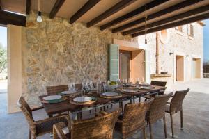 - une salle à manger avec une table et des chaises en bois dans l'établissement Finca Es Vidrier, à Canyamel