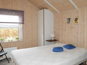 um quarto com uma cama com duas almofadas azuis em Holiday Home Raade III em Årøsund