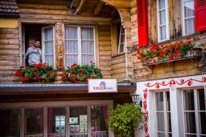a man standing outside of a window in front of a building at Balmers Hostel in Interlaken
