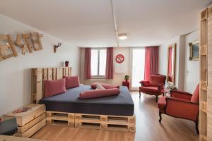 a bedroom with a large bed and two chairs at Balmers Hostel in Interlaken