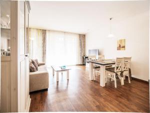 ein Wohnzimmer mit Tisch und Couch in der Unterkunft Dünenpark Binz - Komfortplus Ferienwohnung mit 1 Schlafzimmer und Terrasse im Erdgeschoss 099 in Binz