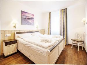 ein großes weißes Bett in einem Zimmer mit Fenster in der Unterkunft Dünenpark Binz - Komfortplus Ferienwohnung mit 1 Schlafzimmer und Terrasse im Erdgeschoss 099 in Binz