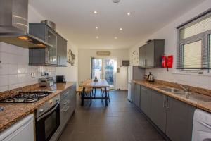 a kitchen with stainless steel appliances and a table at By Lushlets - City Centre Hot tub Pool table - Great for Hens Stags & Rugby groups! in Cardiff