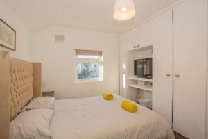 Dormitorio con cama con almohada amarilla en Lushlets - Riverside City Centre House with Hot tub and pool table - great for groups!, en Cardiff