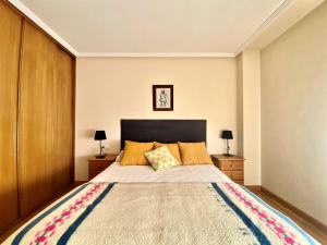 1 dormitorio con 1 cama grande y 2 mesitas de noche en Housingleón - San Marcos con garaje en León