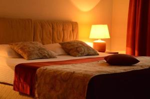 ein Schlafzimmer mit einem Bett mit zwei Kissen und einer Lampe in der Unterkunft Hotel N in Belgrad