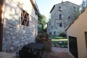 patio ze stołem i budynkiem w obiekcie Mulino in Chianti w mieście Gaiole in Chianti
