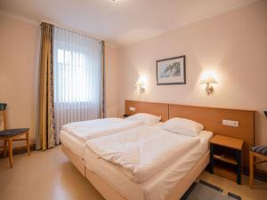ein Schlafzimmer mit großem Bett und Fenster in der Unterkunft Dünenpark Binz - Komfort Ferienwohnung mit 1 Schlafzimmer und Terrasse im Erdgeschoss 118 in Binz