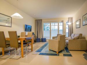 ein Wohnzimmer mit einem Esstisch und Stühlen in der Unterkunft Dünenpark Binz - Komfort Ferienwohnung mit 1 Schlafzimmer und Terrasse im Erdgeschoss 118 in Binz