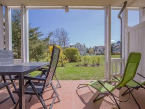 eine Terrasse mit Tisch und Stühlen auf einer Veranda in der Unterkunft Dünenpark Binz - Komfort Ferienwohnung mit 1 Schlafzimmer und Terrasse im Erdgeschoss 118 in Binz