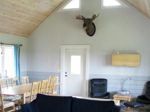 een kamer met een tafel en een hertenkop aan de muur bij 6 person holiday home in LJUNG in Alboga