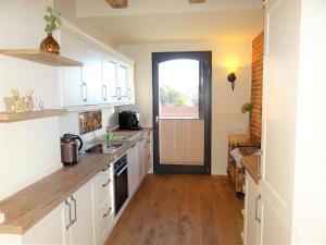 a kitchen with white cabinets and a wooden floor at Speicher Residenz Barth E3 App 9 in Barth