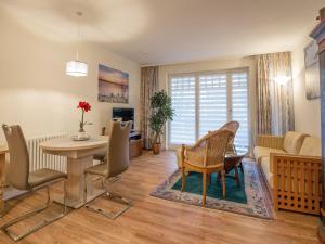 ein Wohnzimmer mit Tisch und Stühlen und einer Couch in der Unterkunft Dünenpark Binz - Komfortplus Ferienwohnung mit 1 Schlafzimmer und Terrasse im Erdgeschoss 128 in Binz