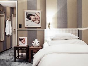 a bedroom with a bed and a side table with a picture at Hotel Kindli in Zurich