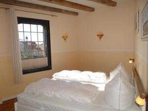 a white bed in a room with a window at Speicher Residenz Barth E3 App 9 in Barth