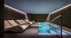 a room with a swimming pool and some chairs and a swimming pool at Hotel Ambasador - Liburnia in Opatija