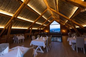 a restaurant with white tables and chairs and a large window at Aurora Borealis Observatory in Silsand