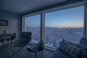 a living room with a large window with a view at Aurora Borealis Observatory in Silsand