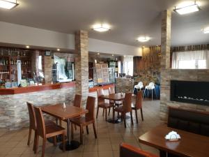 a restaurant with tables and chairs and a fireplace at Noclegi u Danusi in Wizna